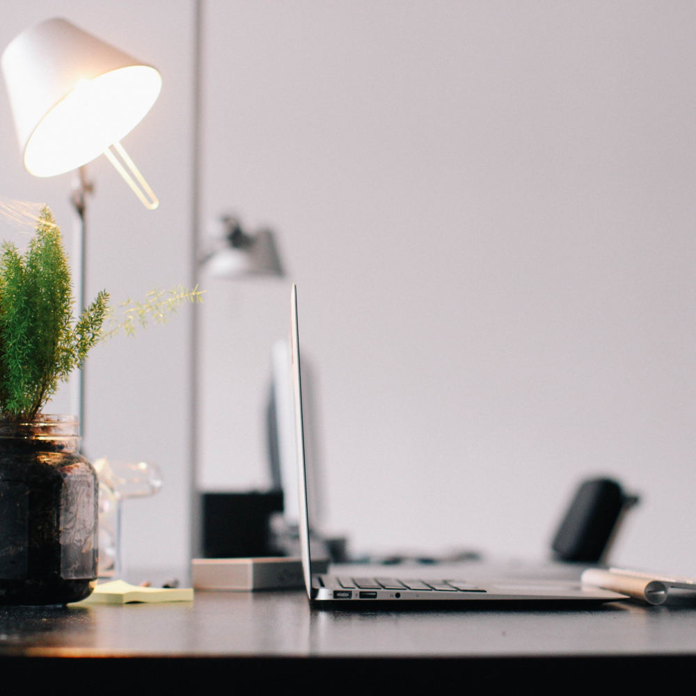 desk with laptop lamp and stationery
