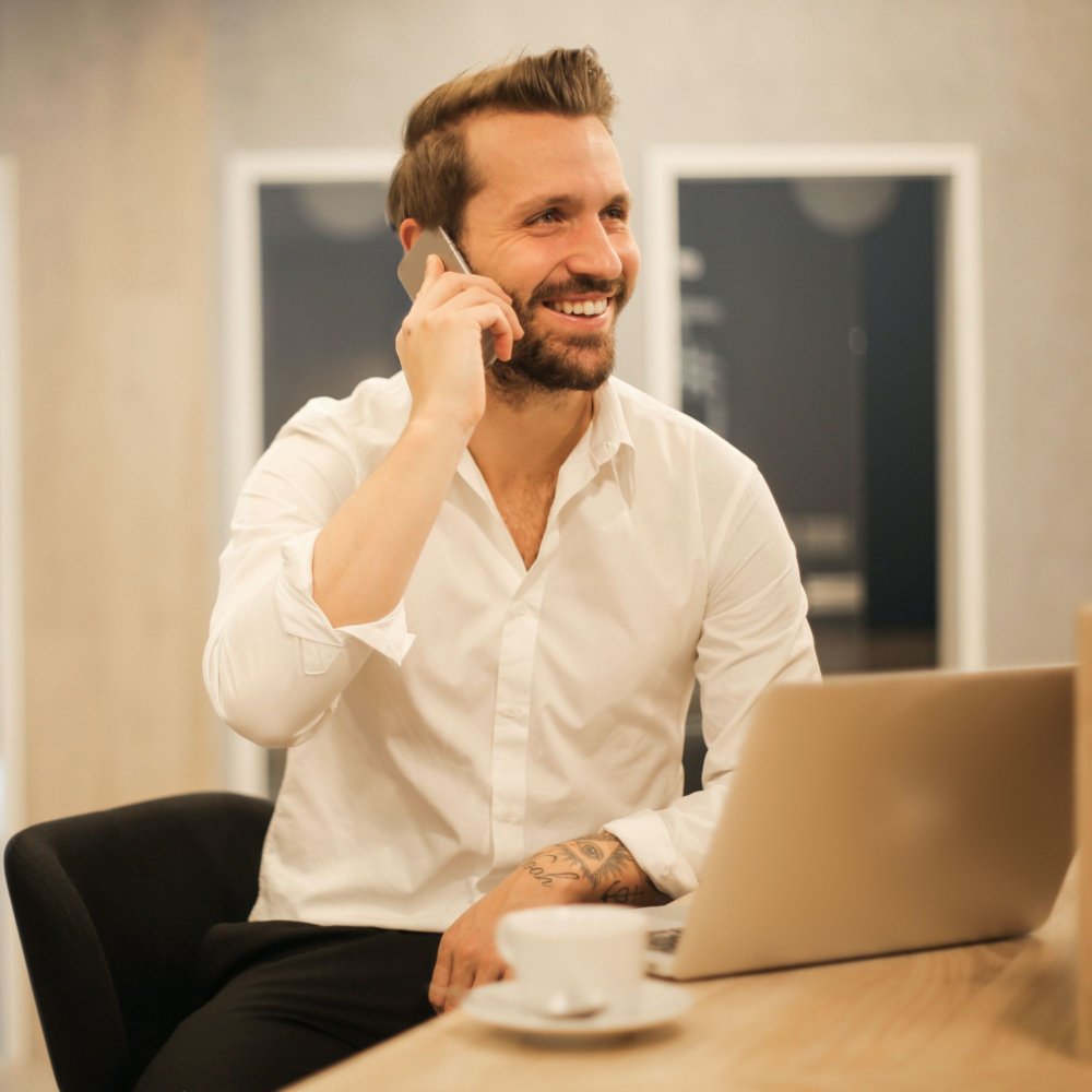 man talking on phone at computer