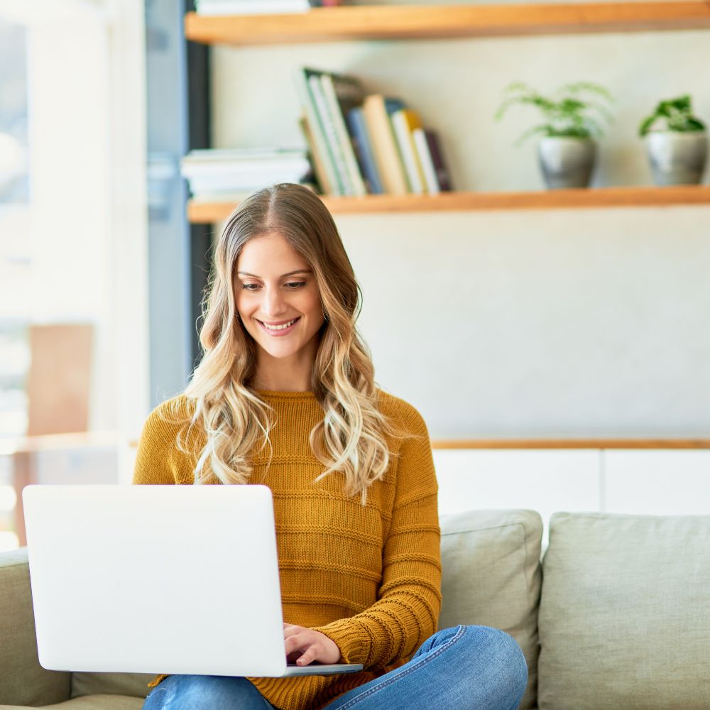 woman with blonde hair sat working on her laptop